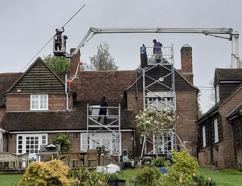 The Moss Cleaners using cherry picker and scaffolding to clean roof safely and professionally in Crawley, West Sussex